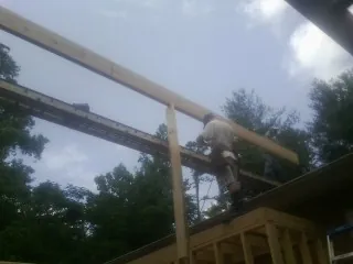 Carpenter setting a ridge beam over a new addition frame — Ice Dam Removal by Roofing Brothers in Phenix City