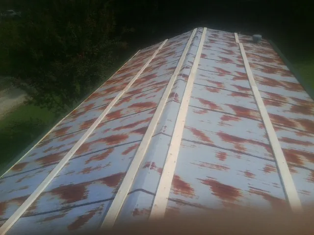 Rusted metal roof panels with new wood purlins before replacement — Storm Damage Roof Repair in Phenix City by Roofing Brothers