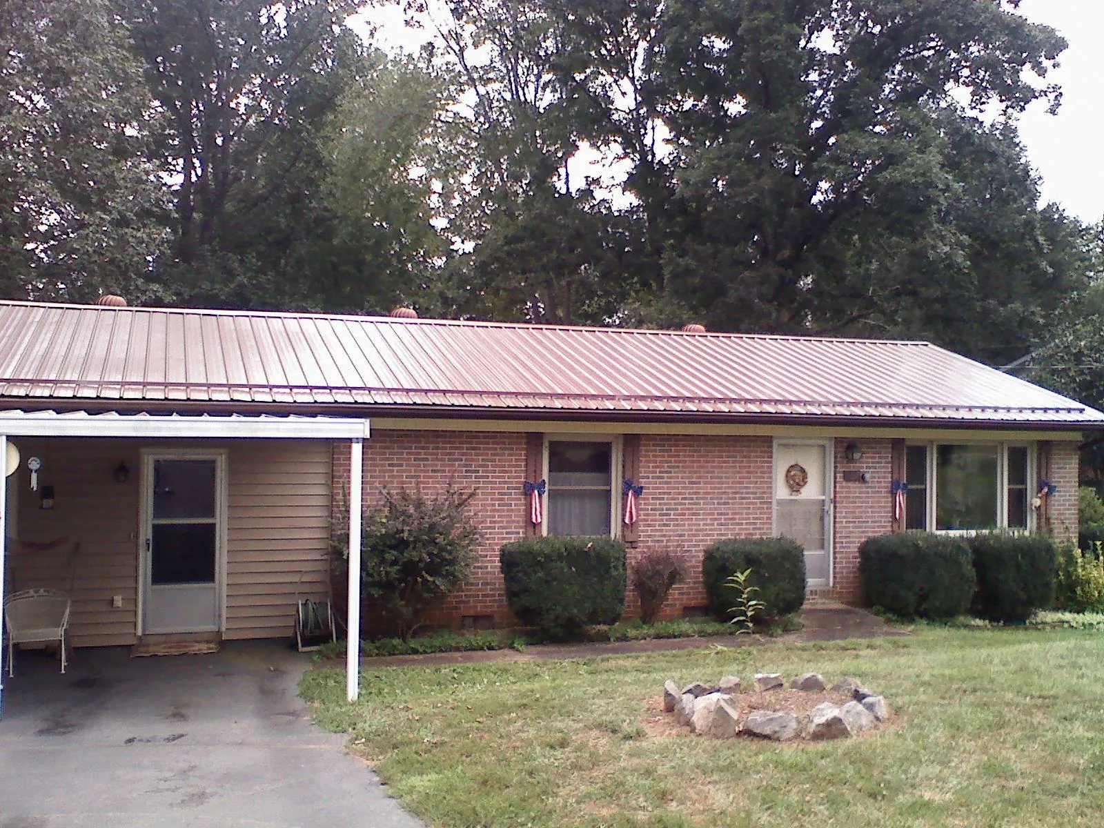 Bronze metal roof and carport on a brick ranch home — Roof Repair work by our crew in Phenix City