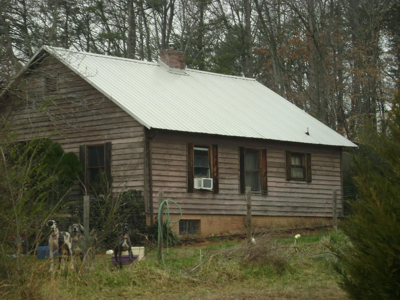 White metal roof on an old wood sided farmhouse, from a Metal Roof Installation job in Phenix City
